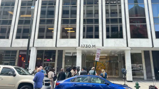 Outside of the building where Bolton maintains his office - there's a group of people gathered outside