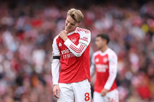 Odegaard holds his shoulder and winces
