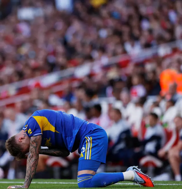A leeds player kneels on the floor as he holds his head after a challenge