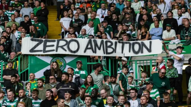 Celtic supporters holding a banner