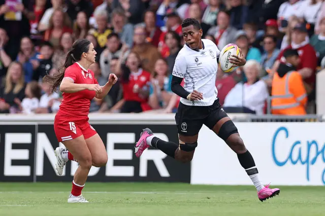 Nunia Daunimoala of Fiji breaks with the ball whilst under pressure from Caroline Crossley