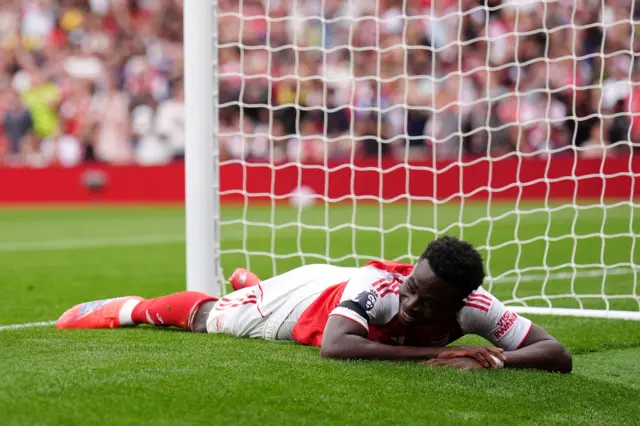 Saka lies on the floor and rues his missed chance