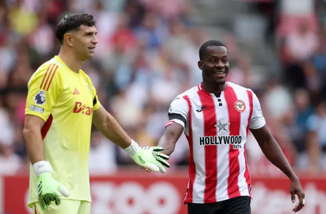 Dango Ouattara of Brentford interacts with Emiliano Martinez