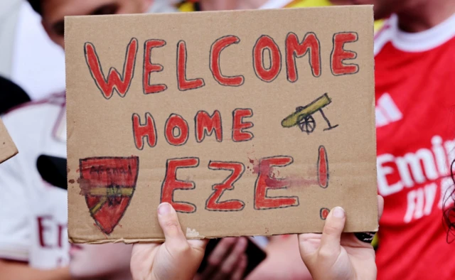 Arsenal fan with a sign in support of new signing Eberechi Eze inside the stadium
