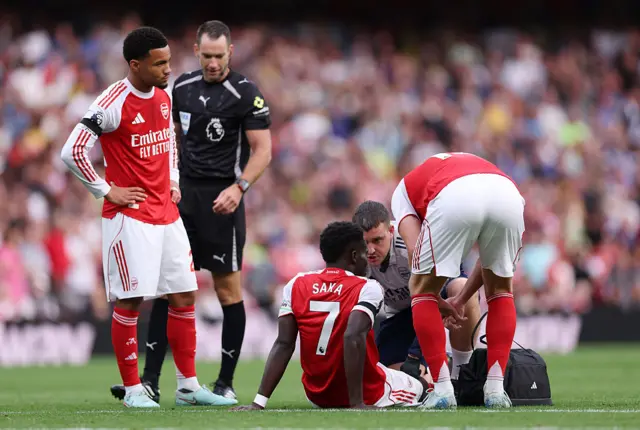 Saka sits down to receive treatment from the physios