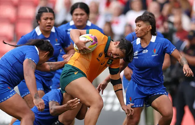 Cecilia Smith (C) runs with the ball
