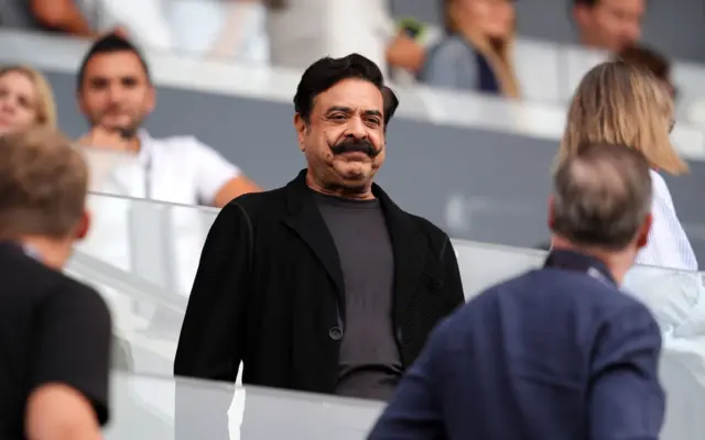 Shaid Khan stands watching the pitch from the stands