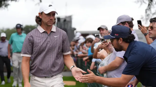 Tommy Fleetwood high fives a fan at East Lake