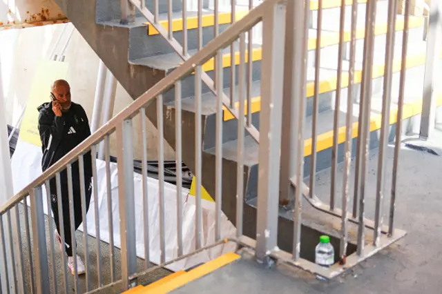 Nottingham Forest manager Nuno Espirito Santo shelters from the sun under a flight of stairs