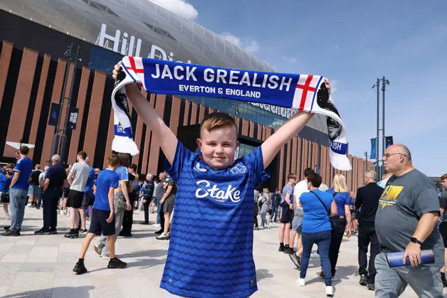 A young fan holds up a Jack Grealish scarf
