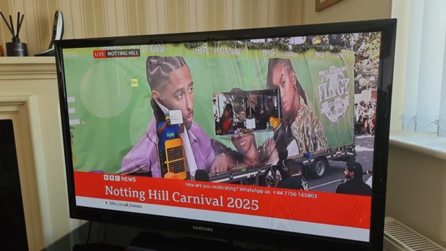 A TV screen which shows the Notting Hill Carnival live stream on the screen