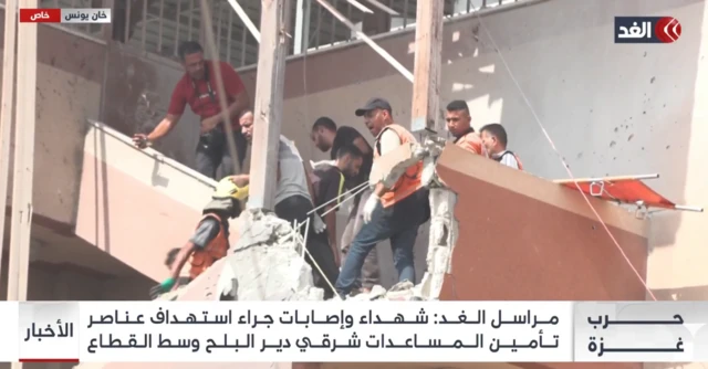 Emergency workers and journalists on a damaged stairway