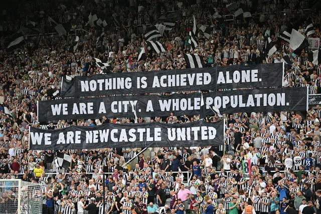 Newcastle fans display banners in the crowd ahead of kick-off in the English Premier League football match between Newcastle United and Liverpool