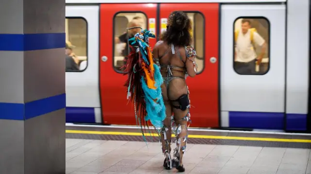 A carnival participant walking towards tube door in full carnival attire