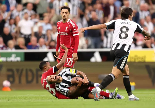 Bruno Guimaraes of Newcastle United reacts after being tackled by Ryan Gravenberch of Liverpool during the Premier League match between Newcastle United and Liverpool at St James' Park on August 25, 2025 in Newcastle upon Tyne, England.