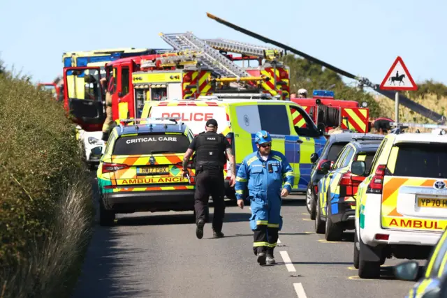 A number of ambulances, fire engines and police cars parked up along Shanklin Road.