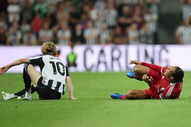 Virgil van Dijk of Liverpool reacts after being fouled by Anthony Gordon o