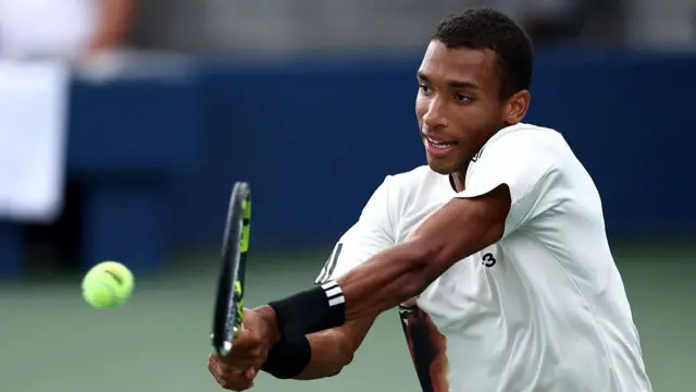 Felix Auger-Aliassime of Canada hits a backhand