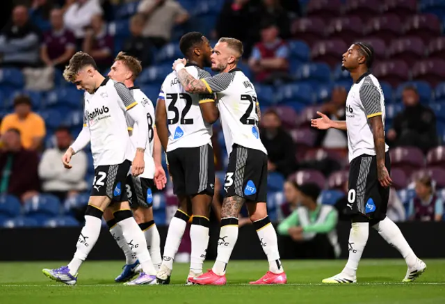Ebou Adams and Joe Ward of Derby County celebrate their team's first goal scored by teammate Bobby Clark