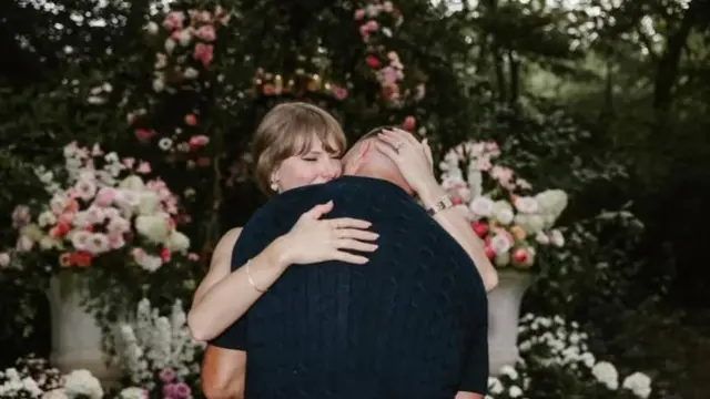 Taylor Swift and Travis Kelce surrounded by flowers
