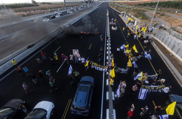 Protesters block a main road during a demonstration demanding the immediate end of the war and the release of all hostages who were kidnapped during the deadly October 7, 2023 attack on Israel by Hamas