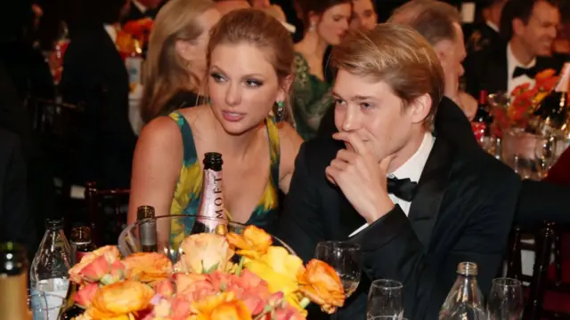 Taylor Swift and Joe Alwyn sat at a table