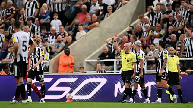 Simon Hooper shows Anthony Gordon a red card