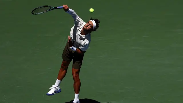 Lorenzo Musetti of Italy serves