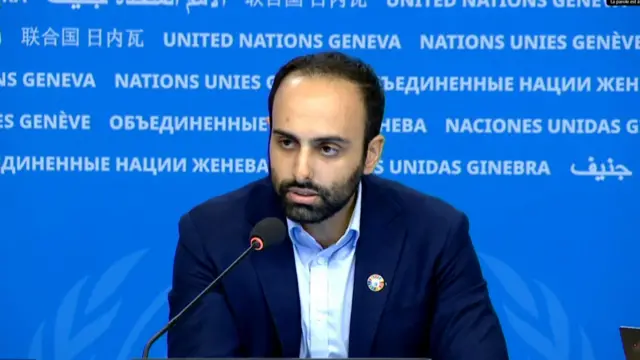 Thameen Al-Kheetan speaks in front of a United Nations blue screen
