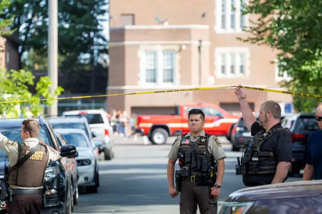 A policeman stands in front of a police cordon