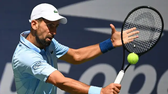 Novak Djokovic plays a backhand return