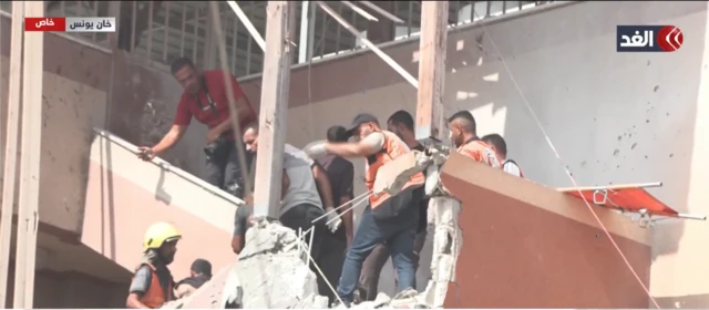Rescue workers and journalists responding to the first strike, moments before they are hit by the second strike