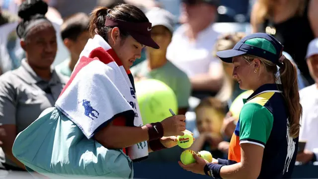 Emma Raducanu of Great Britain signs balls after her second round win