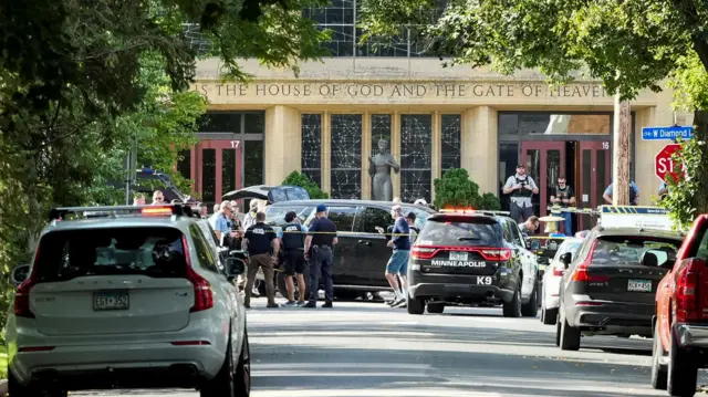 Emergency responders and parked cars outside a sandstone building