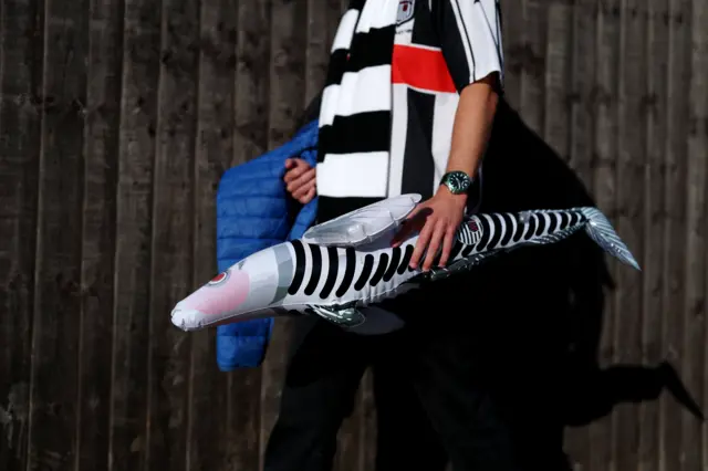Fan carries a blow up haddock to the ground
