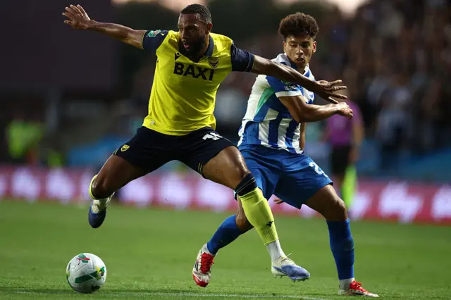 Oxford and Brighton players duel for the ball