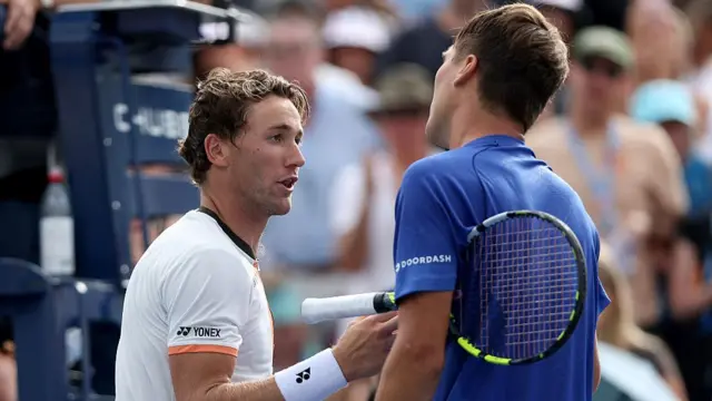 Casper Ruud shakes hands with Raphael Collignon after defeat