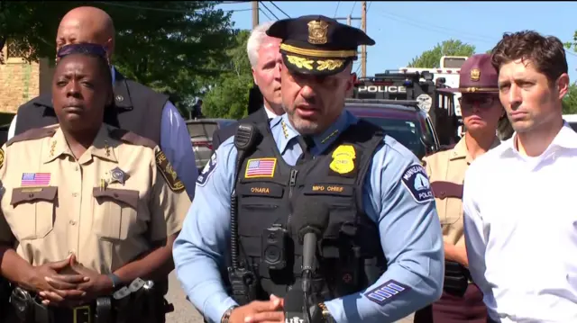 a police chief in a light blue shirt and black hat