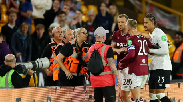 Jarrod Bowen is held back as he tries to a confront a West Ham fan after their EFL Cup defeat Wolves