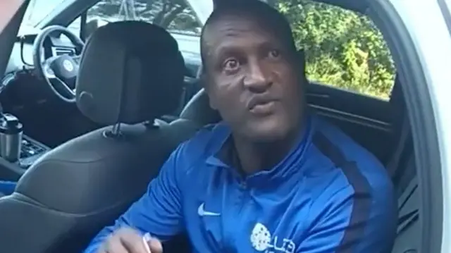 Kebatu in the back of a police car