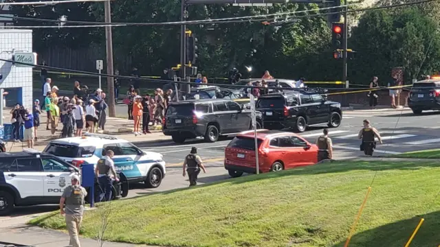 A view of the scene and law enforcement outside Annunciation Catholic School, see from an AutoZone around the corner