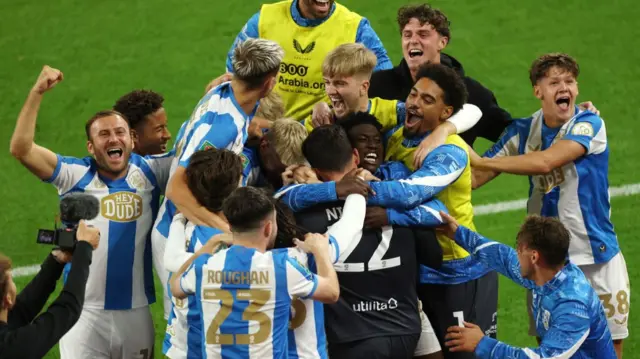 Huddersfield Town players celebrate after goalkeeper Lee Nicholls saves a penalty in an EFL Cup shootout to beat Sunderland