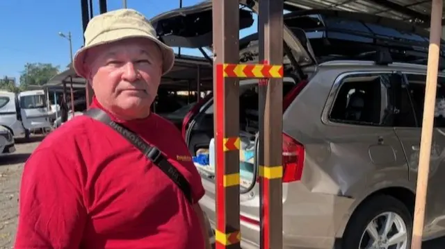 A Ukrainian man standing next to a car