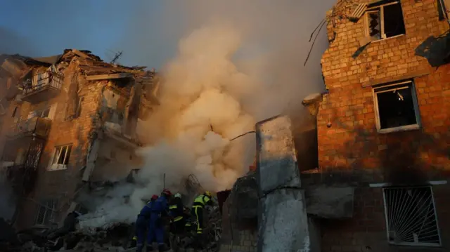 Firefighters entering a smoking building