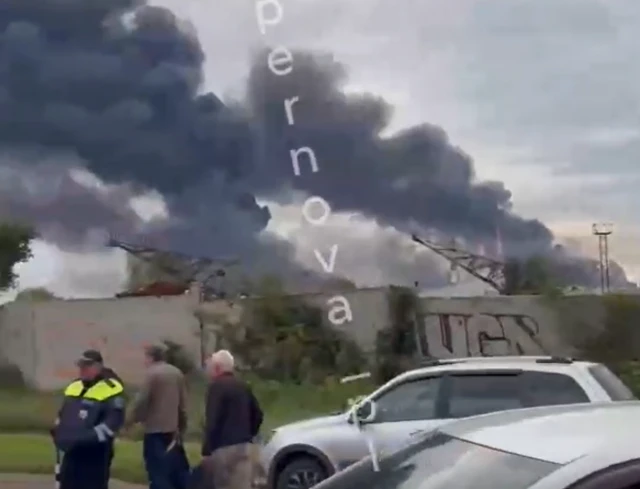 Two plumes of smoke rising from a building