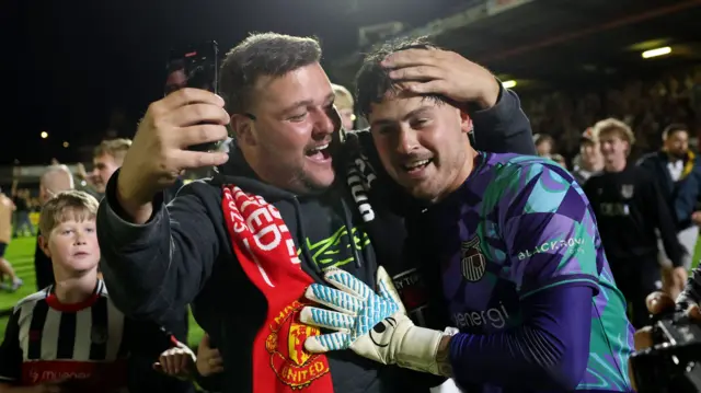 A Grimsby fan takes a selfie goalkeeper Christy Pym after their EFL Cup win over Manchester United