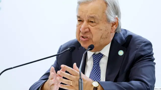 António Guterres gestures as he speaks into a microphone.