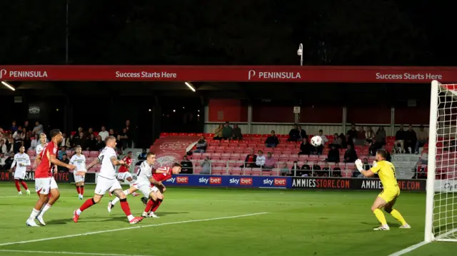 Cheltenham goalkeeper Joe Day saves from Salford's Josh Austerfield