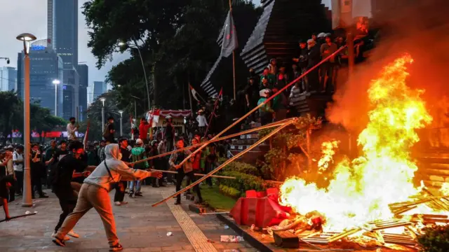 Protesters burn road barriers outside Jakarta's police headquarters