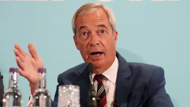 Nigel Farage speaking into a mic on stage